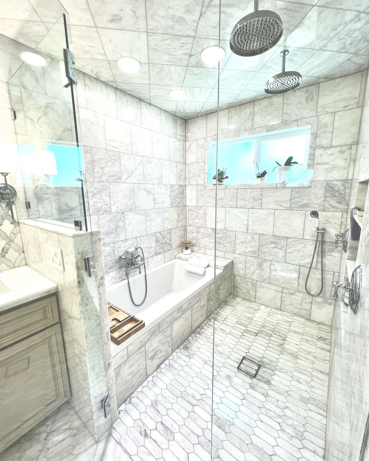 Luxury marble shower with glass enclosure, rain shower head, and built-in tub